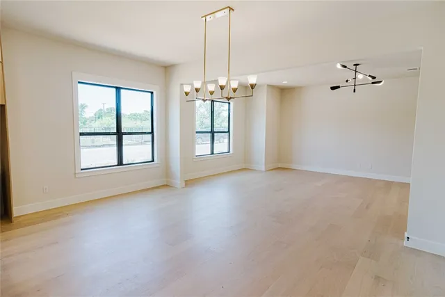 an empty room with windows and chandelier