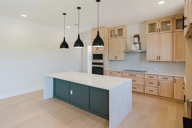 a kitchen with stainless steel appliances granite countertop a refrigerator a oven and white cabinets with wooden floor