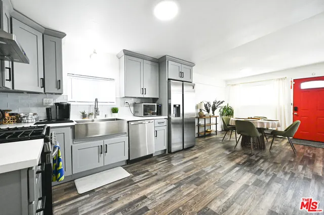 a kitchen with white cabinets and stainless steel appliances