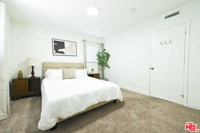 a bedroom with a bed and a potted plant
