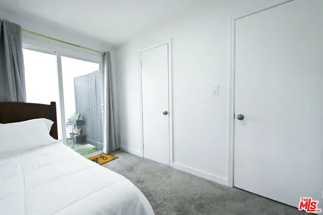 a bedroom with a bed and a potted plant