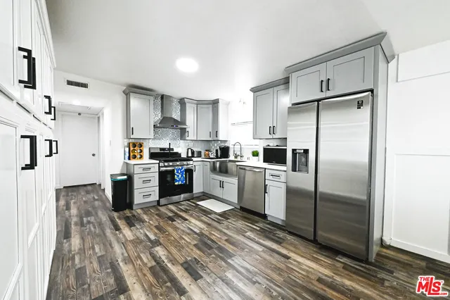 a kitchen with granite countertop a refrigerator oven a sink and dishwasher