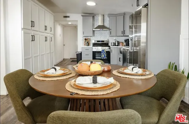 a kitchen with stainless steel appliances granite countertop a dining table and chairs