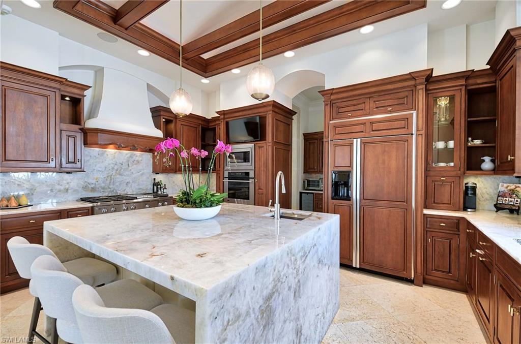 2390 Kingfish Road Naples, FL 34102 - Photo 12 of 37 a kitchen with a table and chairs