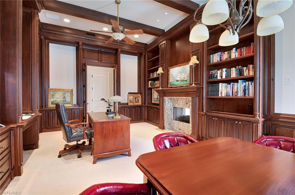 2390 Kingfish Road Naples, FL 34102 - Photo 14 of 37 a living room with fireplace furniture and a book shelf