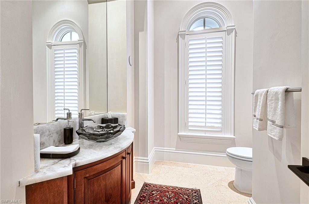2390 Kingfish Road Naples, FL 34102 - Photo 15 of 37 a bathroom with a sink a toilet and a window