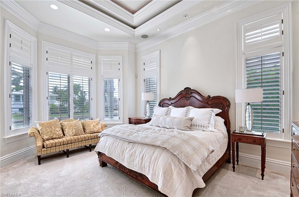 2390 Kingfish Road Naples, FL 34102 - Photo 16 of 37 a spacious bedroom with a bed and a couch