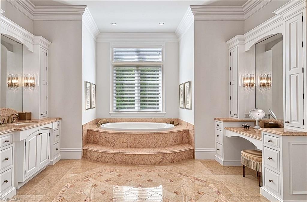2390 Kingfish Road Naples, FL 34102 - Photo 17 of 37 a spacious bathroom with a double vanity sink a mirror and a bathtub