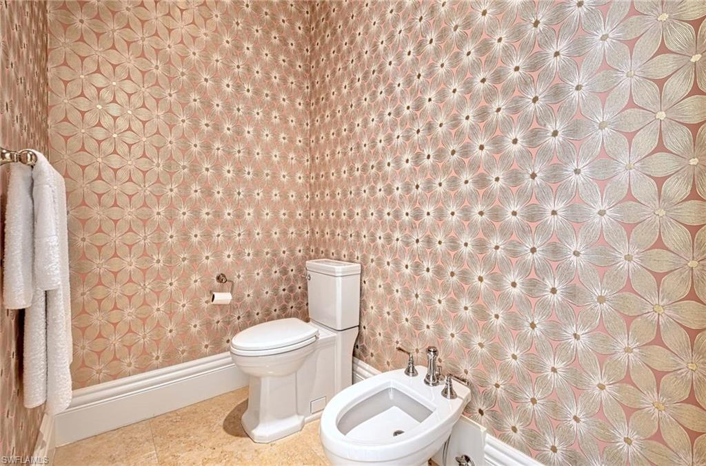 2390 Kingfish Road Naples, FL 34102 - Photo 19 of 37 a white toilet sitting next to a shower curtain