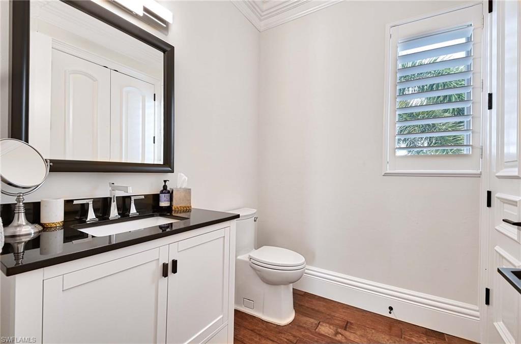 2390 Kingfish Road Naples, FL 34102 - Photo 25 of 37 a bathroom with a granite countertop sink a toilet and a mirror