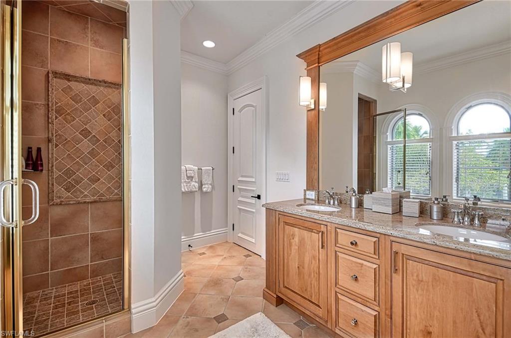 2390 Kingfish Road Naples, FL 34102 - Photo 27 of 37 a large bathroom with a double vanity sink a mirror and a shower