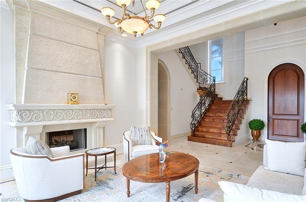 2390 Kingfish Road Naples, FL 34102 - Photo 3 of 37 a living room with furniture a table and a fireplace