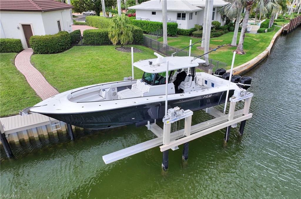 2390 Kingfish Road Naples, FL 34102 - Photo 31 of 37 a view of a chairs and table in patio of a lake