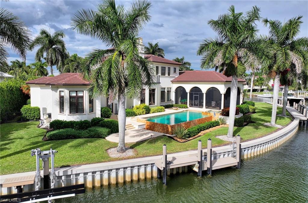 2390 Kingfish Road Naples, FL 34102 - Photo 36 of 37 a aerial view of a house with swimming pool and a garden