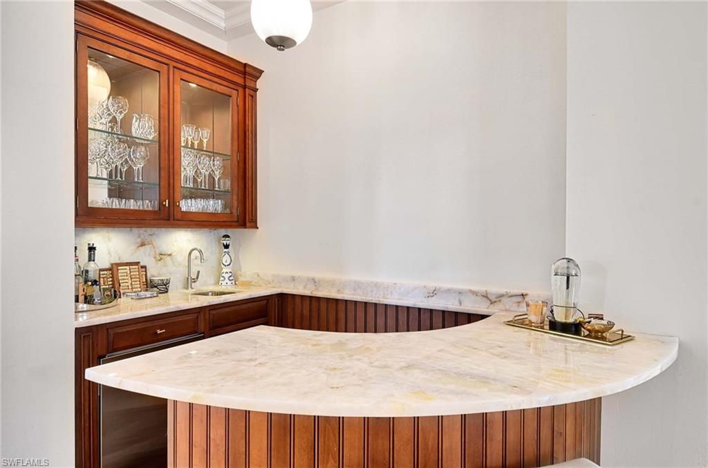 2390 Kingfish Road Naples, FL 34102 - Photo 9 of 37 a kitchen with a sink a stove and cabinets