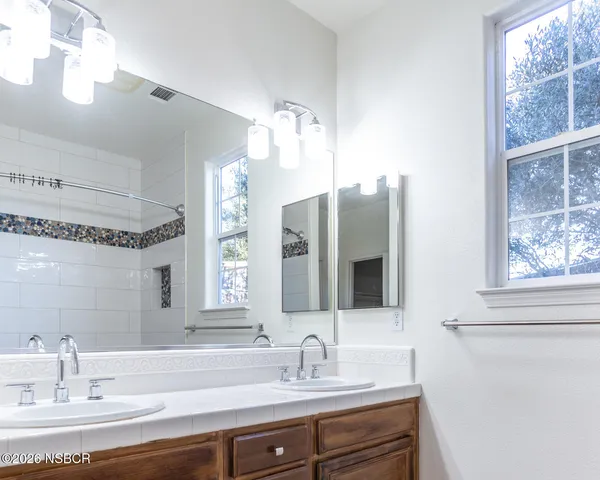 a bathroom with a sink mirror and a bathtub
