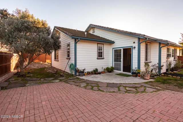 a backyard of a house with table and chairs