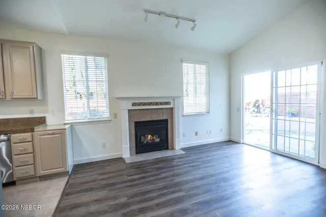 a kitchen with stainless steel appliances granite countertop a stove top oven a sink dishwasher and a refrigerator with wooden floor