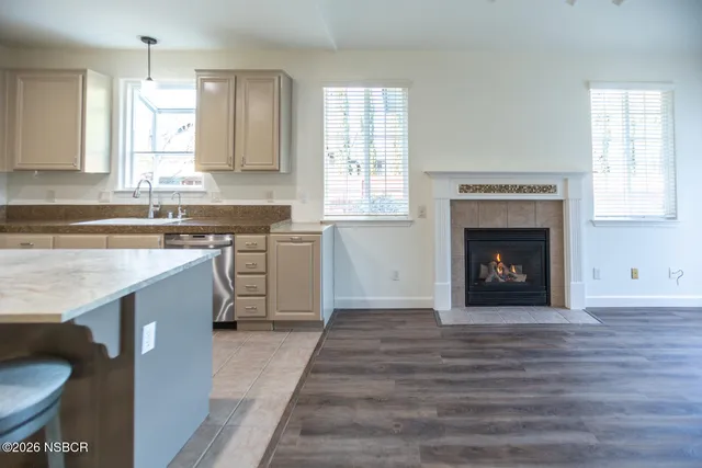 a kitchen with stainless steel appliances granite countertop a stove top oven a sink and a refrigerator