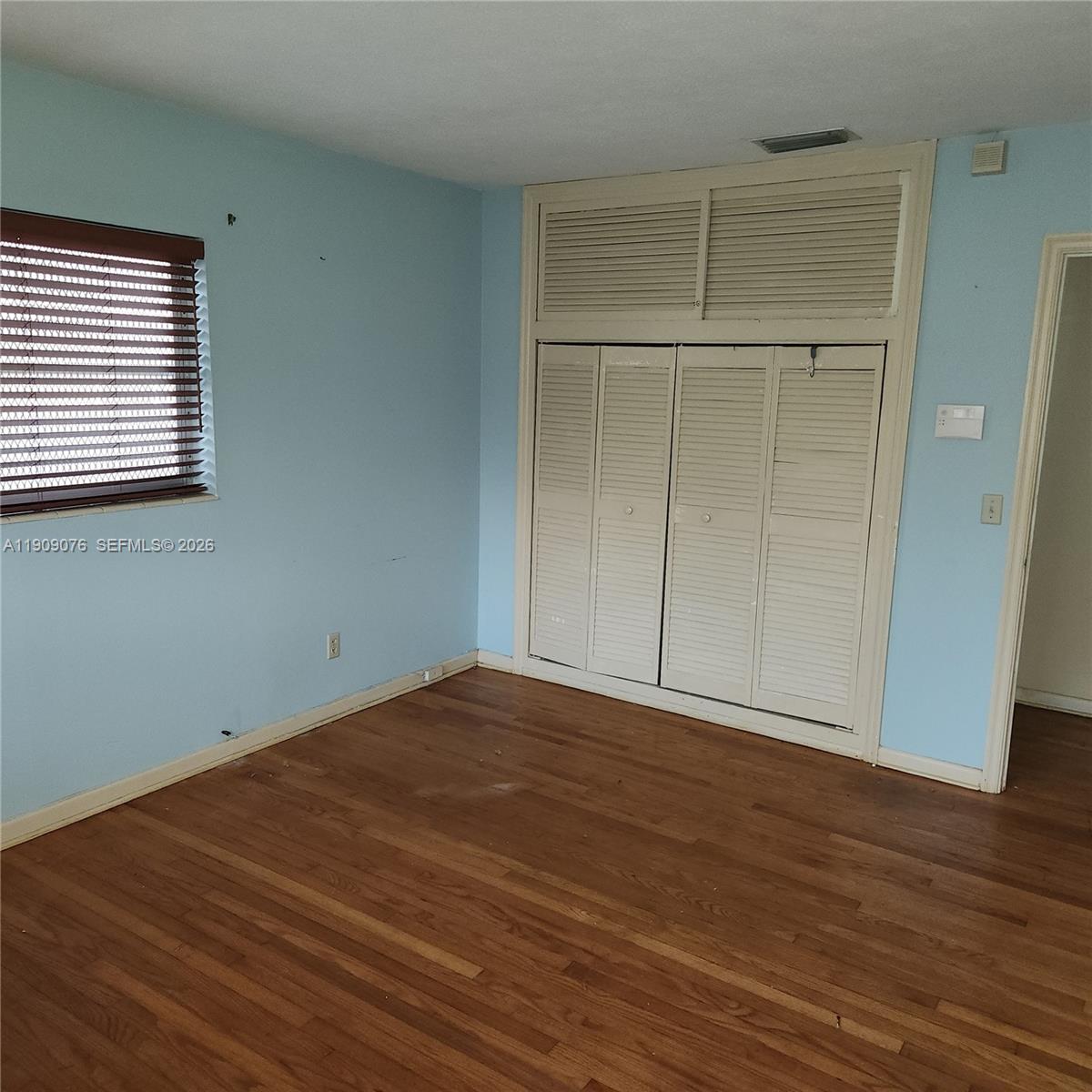 1547 West 10th Street Riviera Beach, FL 33404 - Photo 16 of 20 an empty room with wooden floor and closet area