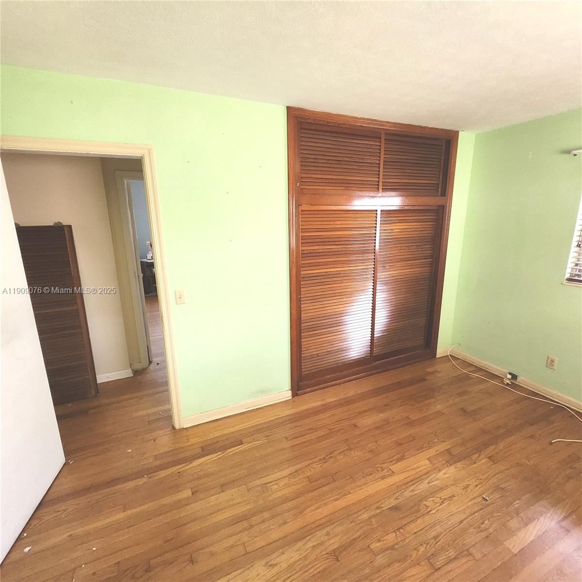 1547 West 10th Street Riviera Beach, FL 33404 - Photo 7 of 10 a view of an empty room with wooden floor and a window