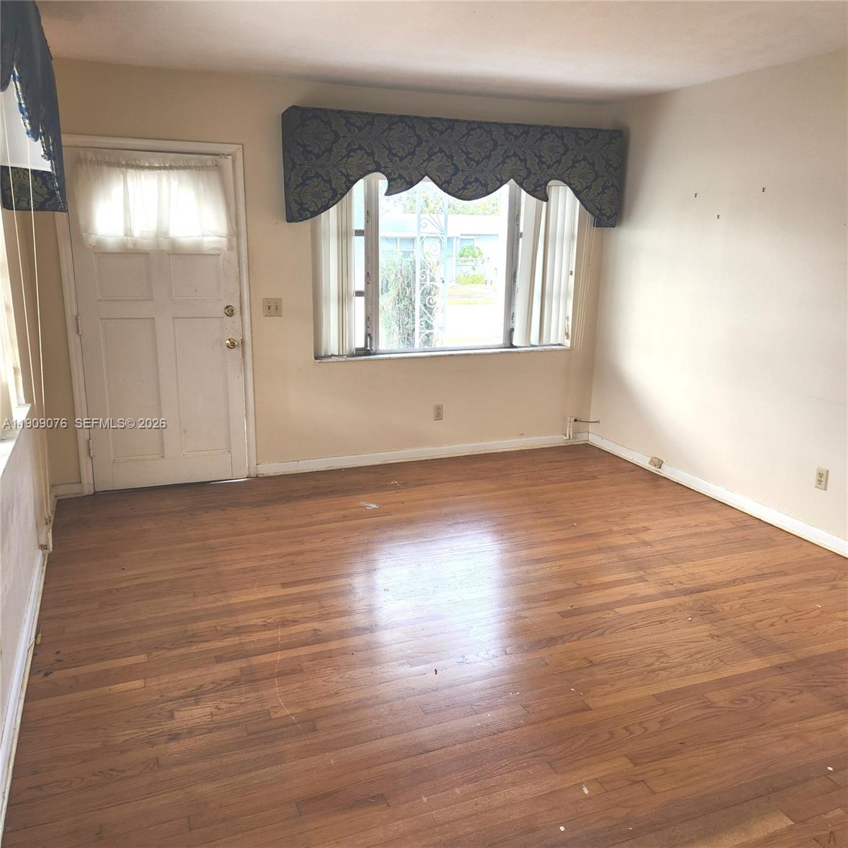 1547 West 10th Street Riviera Beach, FL 33404 - Photo 8 of 20 an empty room with wooden floor and windows