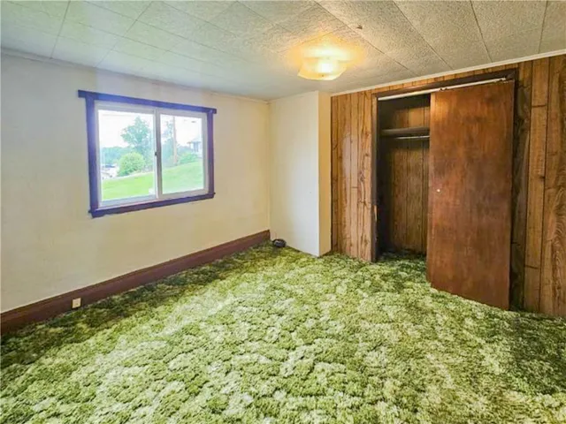 an empty room with a window and wooden floor
