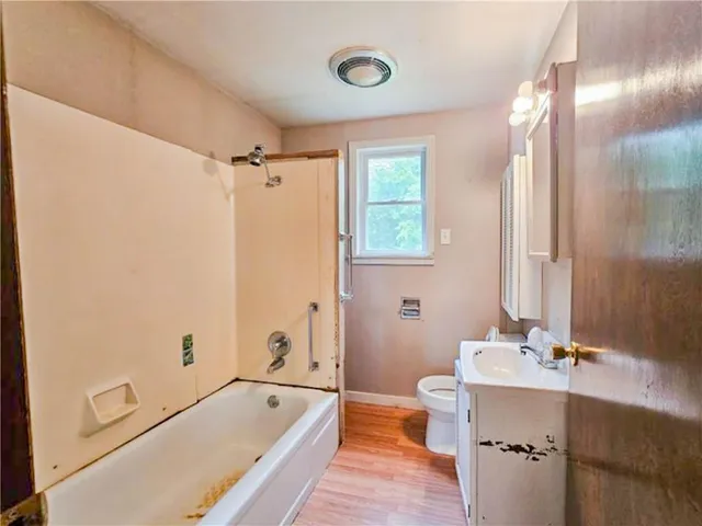 a bathroom with a tub a sink and a window