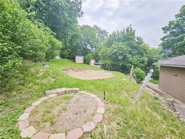 a view of a house with a yard and large tree