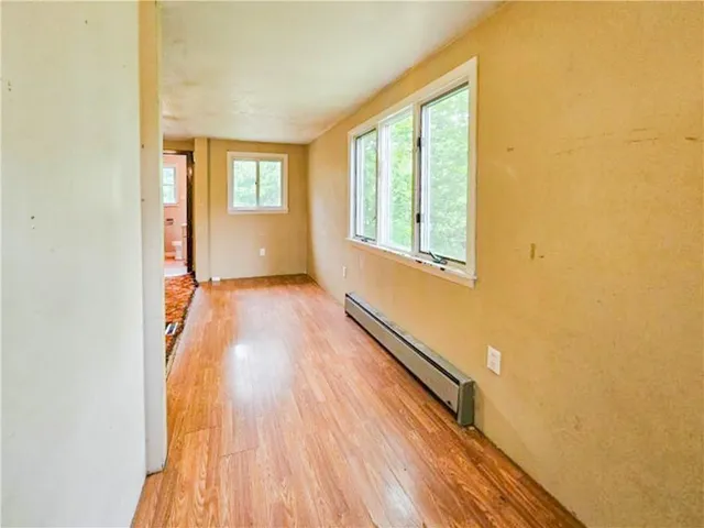 a view of a room with wooden floor and window