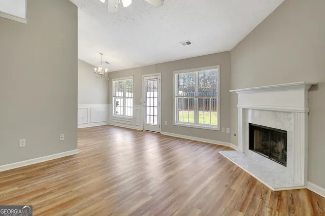 a view of a hallway with wooden floor and cabinet