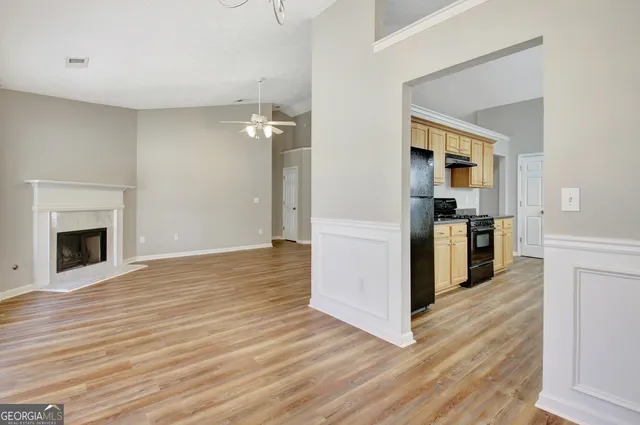 a kitchen with stainless steel appliances granite countertop a stove a sink and a refrigerator with wooden floors