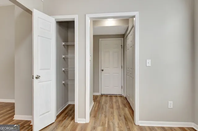 an empty room with wooden floor cabinet and windows