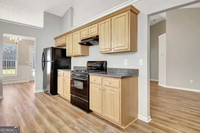 a view of a hallway with wooden floor and a bathroom