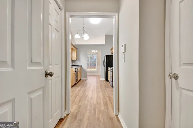 a view of an empty room with a chandelier fan