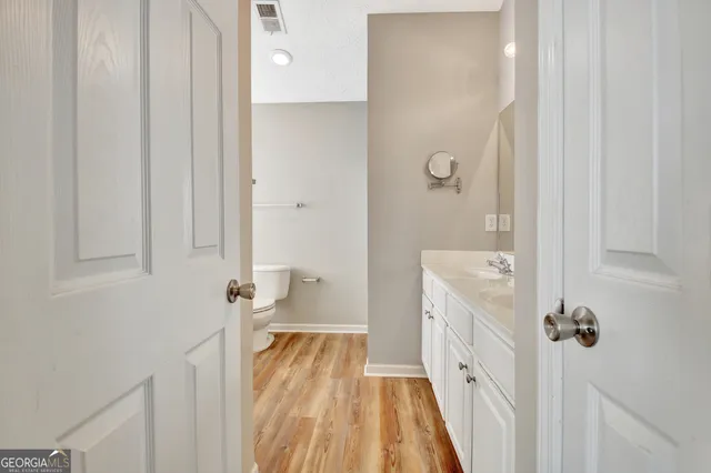 an empty room with windows and chandelier fan