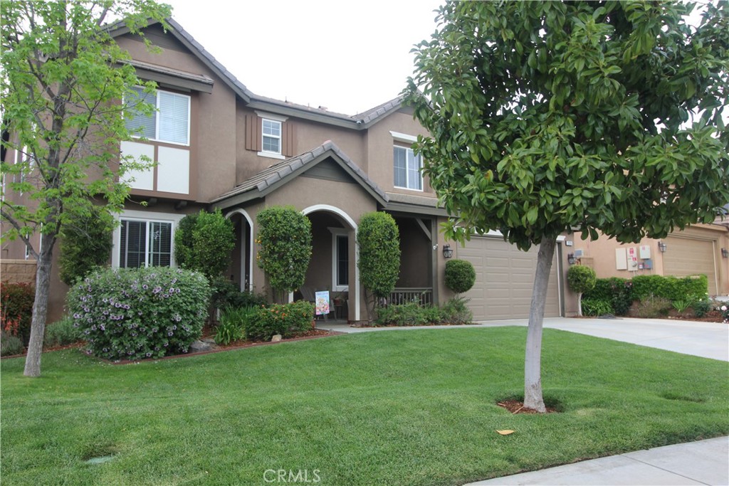 a front view of a house with a yard and trees