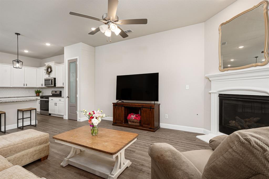 1320 Rosebush Road Aubrey, TX 76227 - Photo 15 of 33 a living room with furniture a flat screen tv and a fireplace