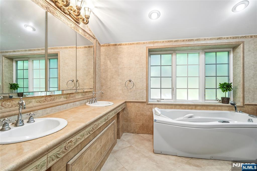 457 Summit Street Norwood, NJ 07648 - Photo 11 of 35 a spacious bathroom with a granite countertop tub sink and mirror