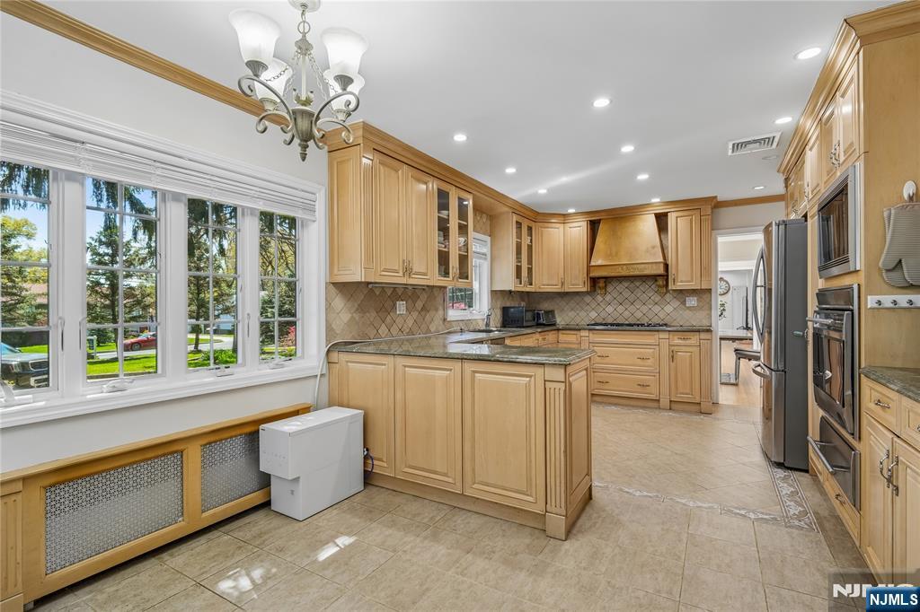 457 Summit Street Norwood, NJ 07648 - Photo 16 of 35 a large kitchen with kitchen island granite countertop a stove a sink a refrigerator and blue cabinets with wooden floor