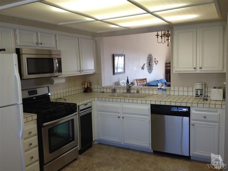 654 Terrace View Place Port Hueneme, CA 93041 - Photo 11 of 30 a kitchen with granite countertop a stove top oven microwave and cabinets