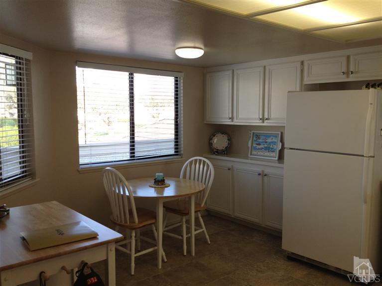 654 Terrace View Place Port Hueneme, CA 93041 - Photo 13 of 30 a kitchen with a table chairs refrigerator and cabinets