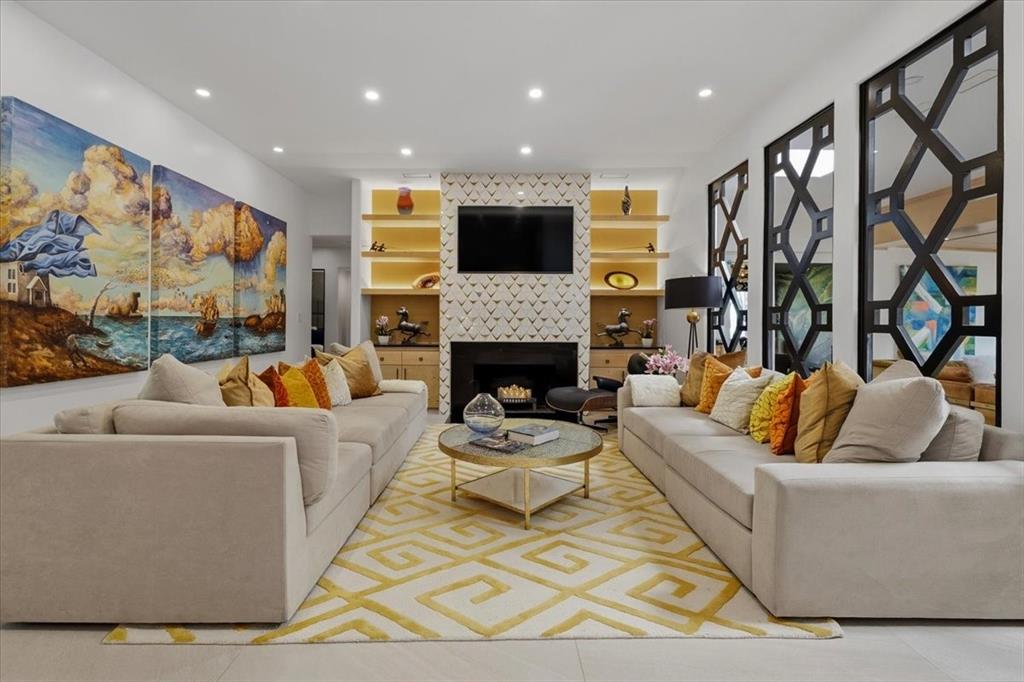 308 North Broadway Road Azle, TX 76020 - Photo 6 of 31 Living area features recessed lighting, a fireplace with marble & Brass decorative tiled surround, and built-in shelving with integrated lighting