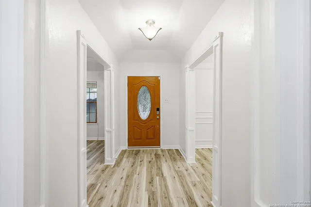 a view of empty room with wooden floor