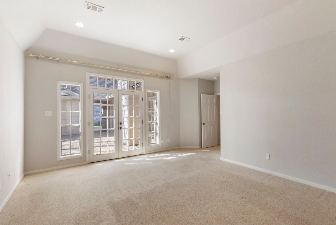 25722 Overlake Drive Spring, TX 77380 - Photo 25 of 50 The spacious primary suite showcases a wall of windows and double French doors leading to the courtyard-style backyard.