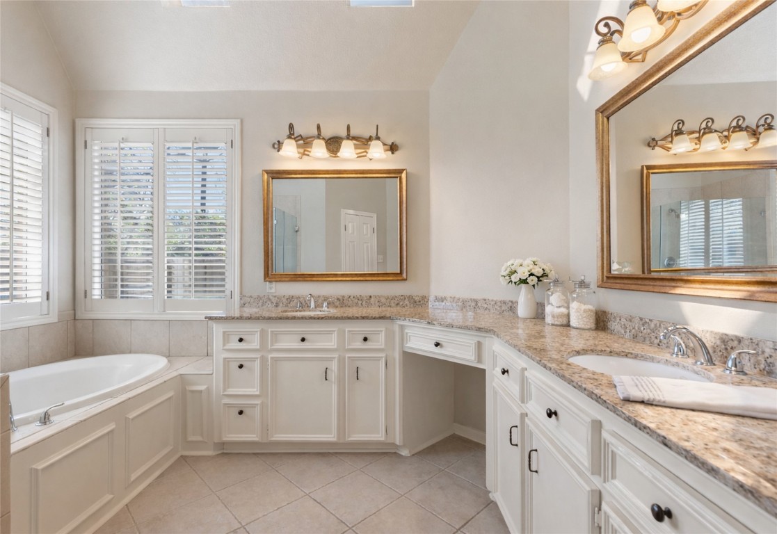 25722 Overlake Drive Spring, TX 77380 - Photo 30 of 50 An additional perspective of the spa-like primary ensuite bathroom. Highlighted by granite countertops, framed mirrors, crown molding, and tile floors.