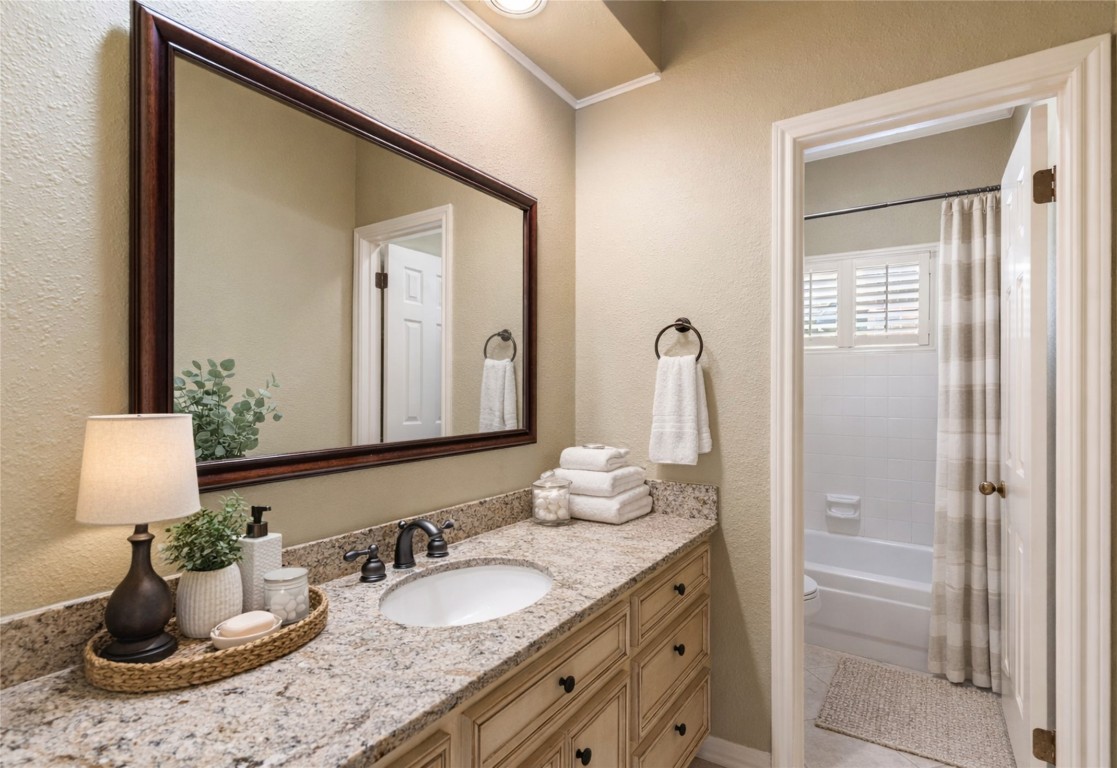 25722 Overlake Drive Spring, TX 77380 - Photo 34 of 50 Conveniently serving all secondary bedrooms, this bathroom showcases updated granite countertops, an oversized framed mirror, and a private shower area with a window that brings in natural light, complemented by plantation shutters.