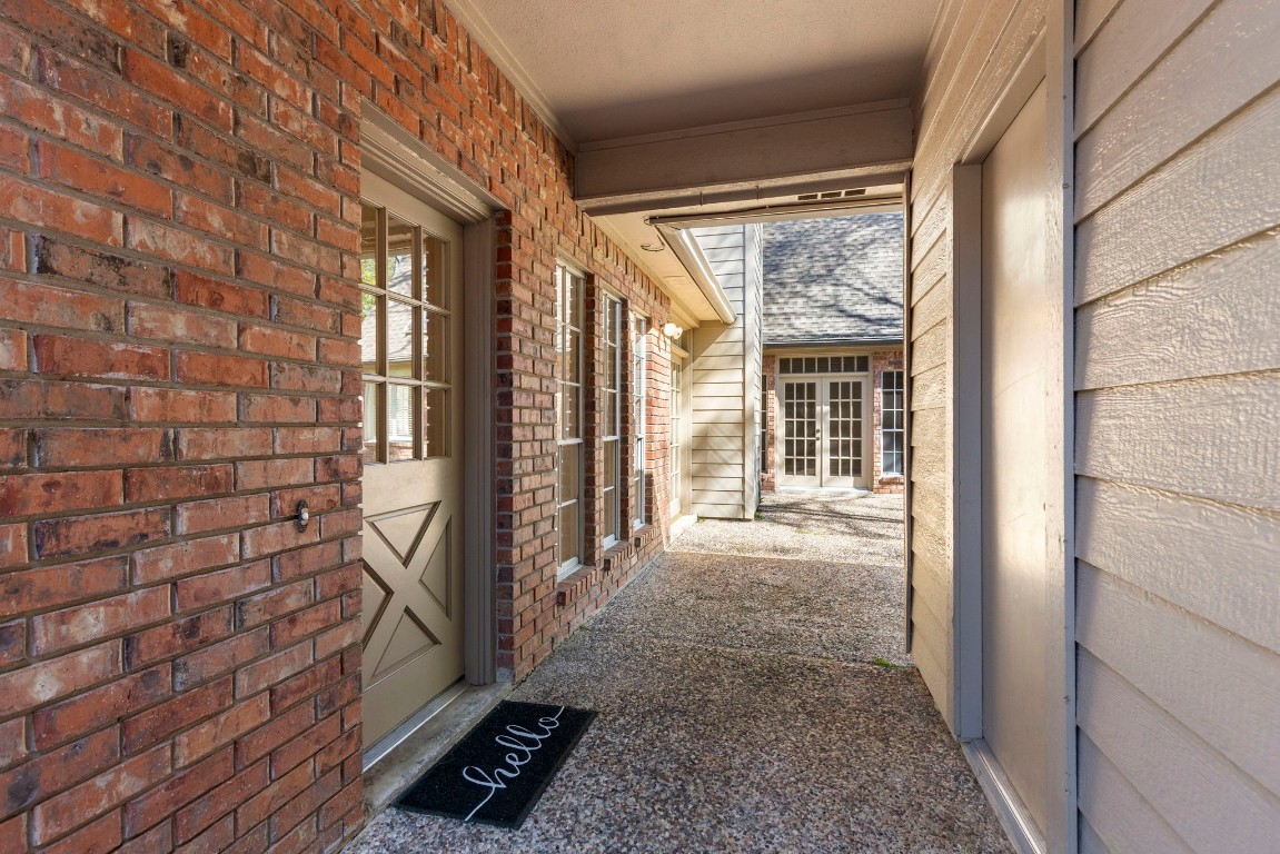 25722 Overlake Drive Spring, TX 77380 - Photo 43 of 50 This photo highlights the passage to the courtyard-style backyard, with the garage door to the right and a rear entry into the laundry room to the left. The combination of brick and siding adds even more character to the home.