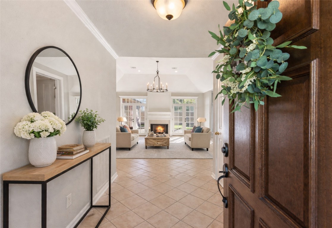 25722 Overlake Drive Spring, TX 77380 - Photo 6 of 50 A raised, tile-floored foyer welcomes you in, complete with a coat/storage closet to the right and a view into the sunken living room, where abundant natural light, a cozy fireplace, chandelier, and backyard-facing windows create an inviting atmosphere.