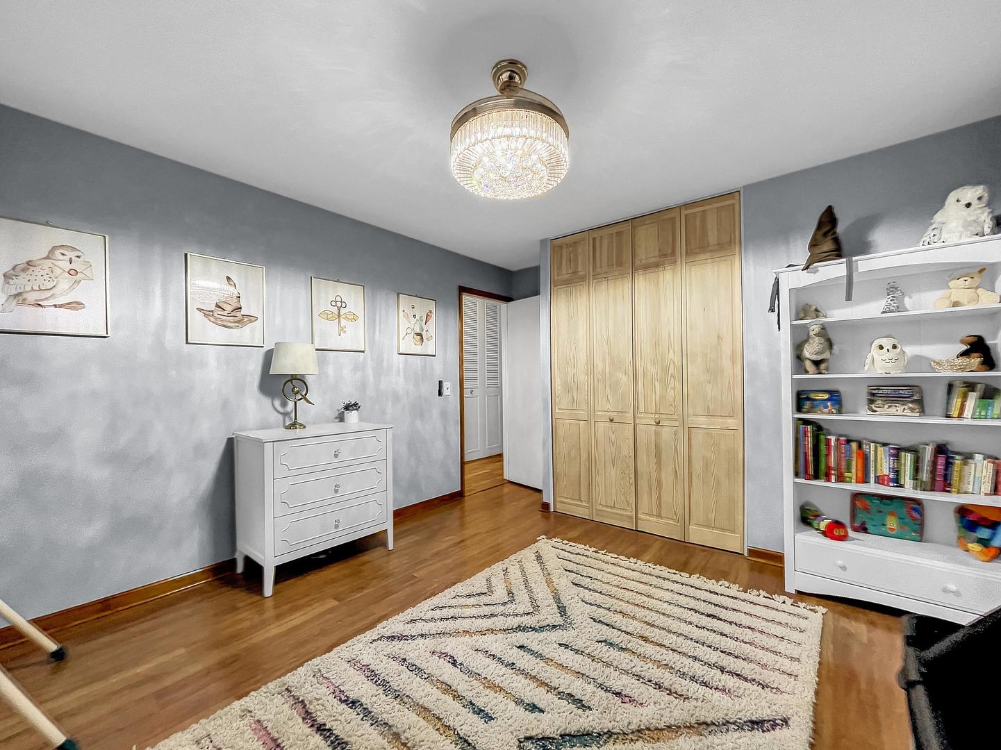 25 Aldon Road Montgomery, IL 60538 - Photo 20 of 38 a spacious bedroom with a bed and a chandelier